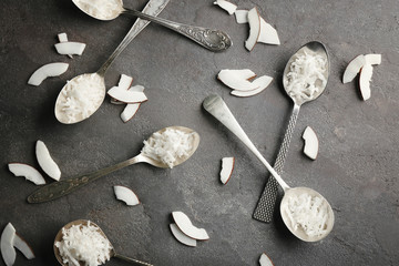 Composition with coconut shavings and vintage spoons on gray background