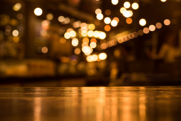 Wood table top with reflect on blur of lighting in cafe,restaurant background/selective focus. - obrazy, fototapety, plakaty