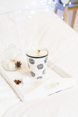 Breakfast in bed - tray with cup of coffee and marshmallows, cozy hygge home style