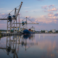 Bulk carrier moored at the quay, and busy with cargo operations.Commercial port in Szczecin, Poland