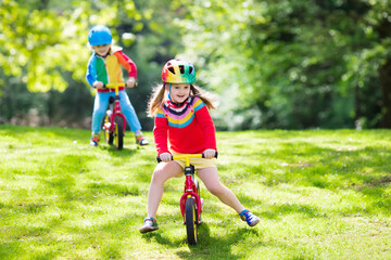 Kids ride balance bike in park