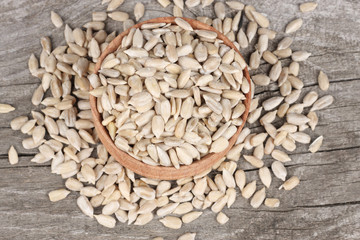 Sunflower seeds in bowl on old wooden table