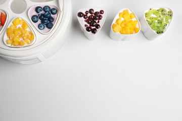 Automatic yogurt maker with fruits on white background