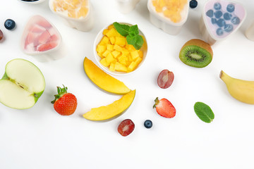 Bowls from automatic yogurt maker with fruits on white background