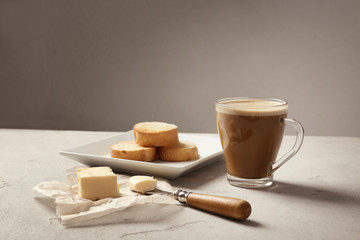 Composition with tasty butter coffee and toasts on table
