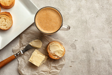 Composition with tasty butter coffee and toasts on grey table