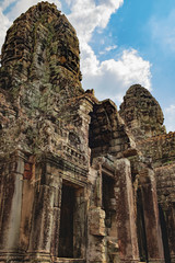 Fototapeta na wymiar Long corridors and doorway of Prasat Bayon, the central temple of Angkor Thom Complex, Siem Reap, Cambodia. Ancient Khmer temple with frescoes and columns, World Heritage.
