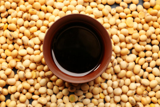 Bowl with tasty soy sauce and beans, closeup