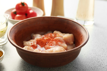 Fresh chicken slices in bowl on kitchen table