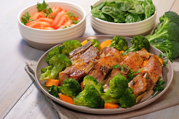 Pork ribs baked in oven with broccoli on plate.