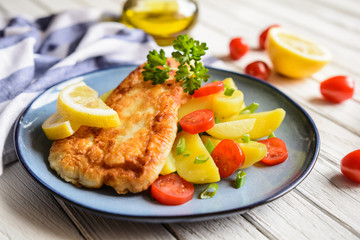 Fried fish fillets in batter, served with potato, tomato and scallion