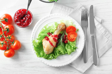 Portion of chicken and cranberry sauce on plate