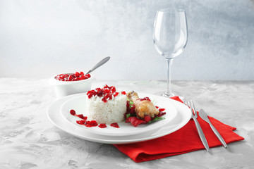 Portion of rice and chicken with cranberry sauce on plate