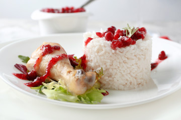 Portion of rice and chicken with cranberry sauce on plate