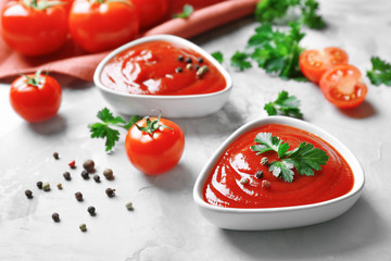 Delicious ketchup in bowls with ingredients on grey background, closeup