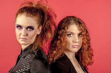 Two young red-haired girls in bright make-up

