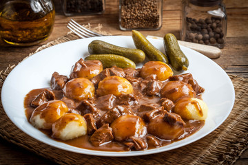 Stew served with silesian noodles and sauce.