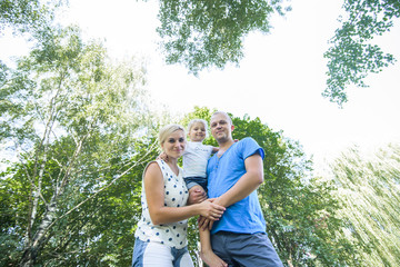 Fototapeta premium Happy young family spending time together outside in green nature.