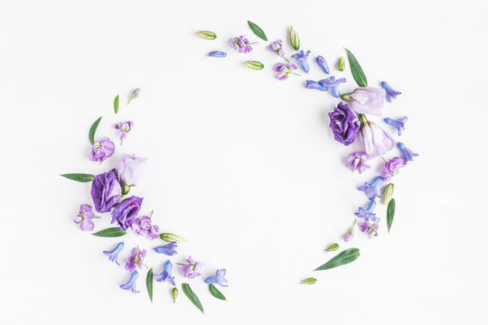 Flowers composition. Wreath made of various purple flowers on white background. Flat lay, top view