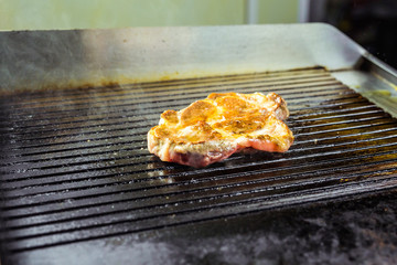 Grilled beef steak on the grill, close-up.