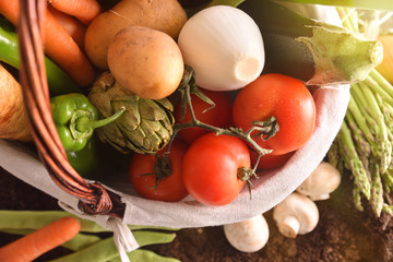 Vegetables in basket on soil top close up