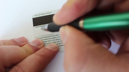 Businessman is putting signature on the credit card in the bank