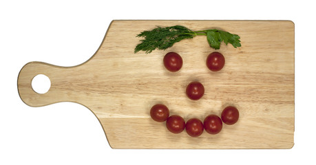 Smile of tomatoes on a wooden board on white background