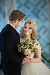 Beautiful young newlyweds in wedding dresses in a modern interior