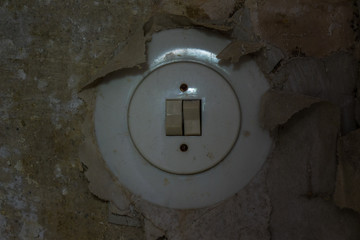 Old electrical switch on a decrepit wall, lost places - obrazy, fototapety, plakaty