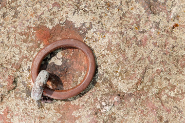 Iron round ring, mounted on a stone surface, background