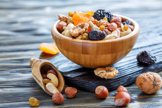 Dried fruits and nuts mixed in wooden bowl.
