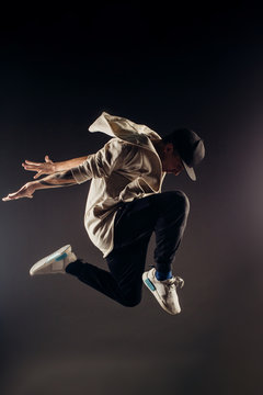 Jumping young male dancer on grey background