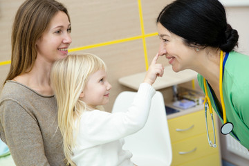 Beautiful woman and her cute little daughter visiting pediatrician
