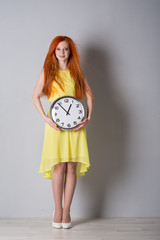 woman in yellow dress with clock