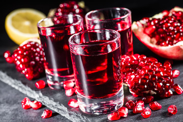 Fresh red juice cocktail with pomegranate seeds and ice