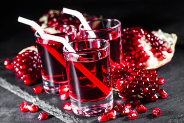 Fresh red juice cocktail with pomegranate seeds and ice