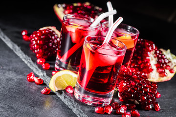 Fresh red juice cocktail with pomegranate seeds and ice