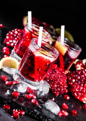 Fresh red juice cocktail with pomegranate seeds and ice