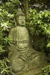 Sitting Buddha sculpture in a zen garden