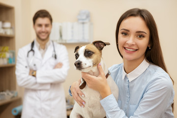 Beautiful young woman at the vet examination with her dog