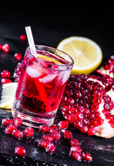 Fresh red juice cocktail with pomegranate seeds and ice