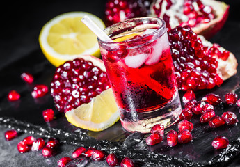 Fresh red juice cocktail with pomegranate seeds and ice