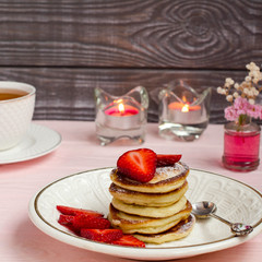 Pancakes with strawberries and tea