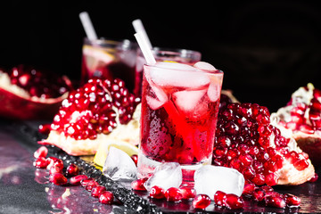 Fresh red juice cocktail with pomegranate seeds and ice
