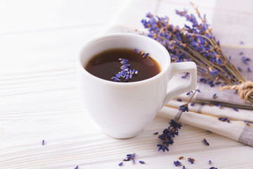 Cup of coffee with lavender flowers on table