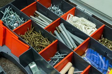 A box with screws, dyupels, fasteners.