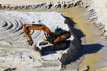 Bagger trägt Sand in Tagebau ab 