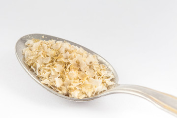 Quinoa flakes (Chenopodium quinoa) isolated on white background