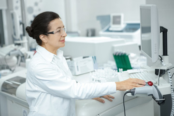 Professional scientist using computerized laboratory machine during the research
