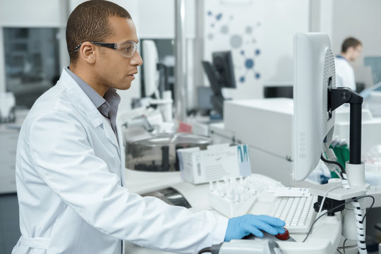 Professional scientist using computerized laboratory machine during the research